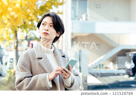 A woman looking at a smartphone outdoors A woman looking at a smartphone outdoors 121528789