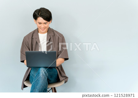 Young Asian man using a computer, notebook, pc, laptop (talking, conversation) Young Asian man using a computer, notebook, pc, laptop (talking, conversation) 121528971