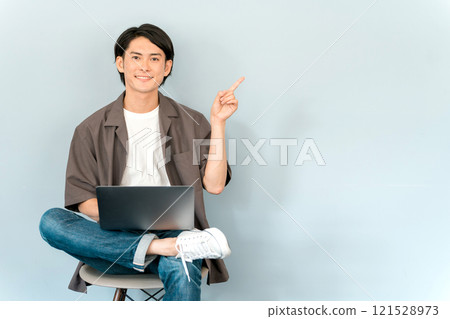 使用電腦/筆記型電腦/筆記型電腦的年輕亞洲男子(說話/對話) 使用電腦/筆記型電腦/筆記型電腦的年輕亞洲男子(說話/對話) 121528973