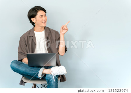 使用電腦/筆記型電腦/筆記型電腦的年輕亞洲男子(說話/對話) 使用電腦/筆記型電腦/筆記型電腦的年輕亞洲男子(說話/對話) 121528974