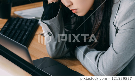 A woman/businesswoman holding her head in frustration A woman/businesswoman holding her head in frustration 121529857