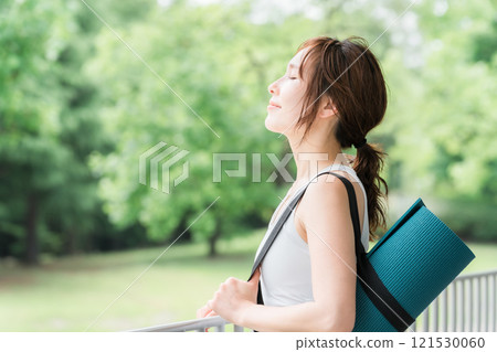 在公園裡做瑜珈以冥想、緩解壓力和提神、瑜珈墊的女性 121530060
