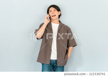 一名年輕的亞洲男子拿著智慧型手機打電話（談話/對話） 121530741