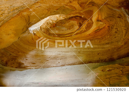 Round yellow cave from inside with spiral pattern on a ceiling. 121530920