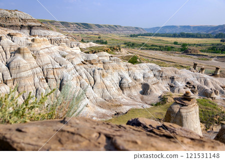 Canyon in badlands with eroded formations on the hills in summer. 121531148