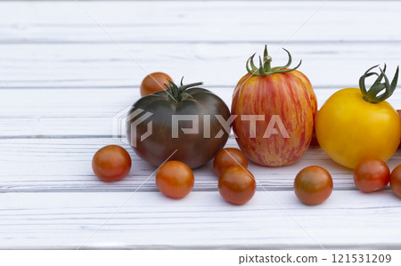 Variety of colorful tomatoes on the white wooden rustic table. 121531209