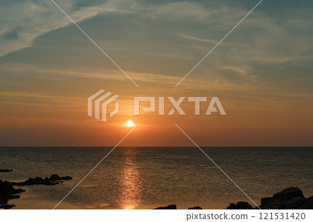 Quiet coastal scenery with the setting sun 121531420