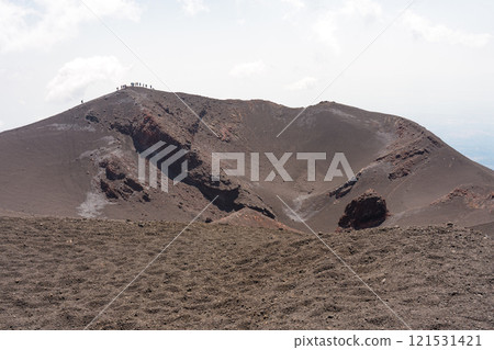 The stark landscape of Mount Etna and people walking along the hills 121531421