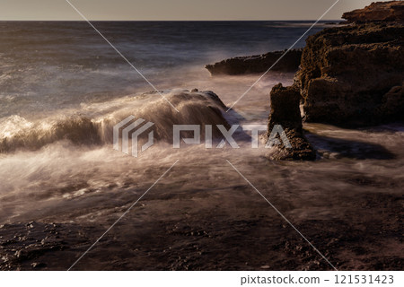 Rugged coastal landscape with waves crashing on rocks Rugged coastal landscape with waves crashing on rocks 121531423