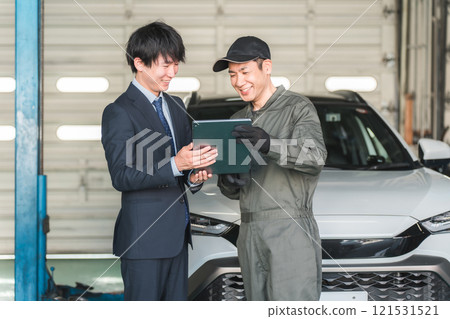 Mechanic and front man in the pit of a repair shop (diagnosis, maintenance, computer diagnosis) Mechanic and front man in the pit of a repair shop (diagnosis, maintenance, computer diagnosis) 121531521