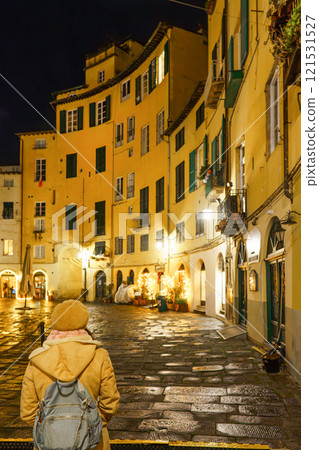 Traveler looking at Lucca's Amphitheatre square at night. 121531527