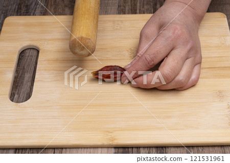 用擀麵杖敲打、敲碎梔子果，製作金頓。 121531961