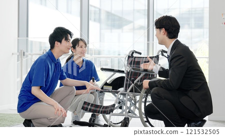 A caregiver and a welfare equipment specialist consultant talking about nursing care products 121532505