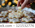 Festive Holiday Sugar Cookies with White Icing and Sprinkles 121532776