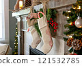 Christmas Stockings, Candy Canes, and Festive Decor on Fireplace Mantel 121532785