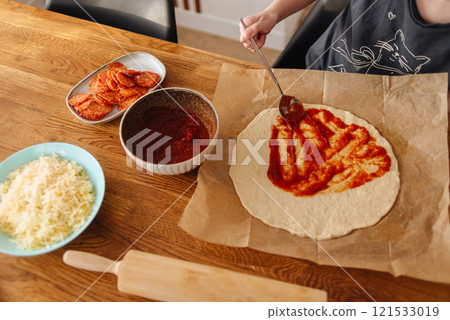 little girl making pizza dough on wooden tabletop in kitchen little girl making pizza dough on wooden tabletop in kitchen 121533019