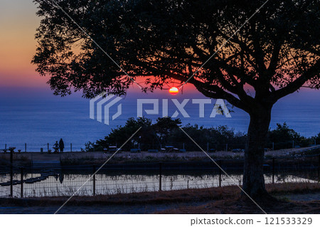 The sun sets and the sky turns red 121533329