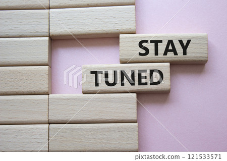 Stay Tuned symbol. Wooden blocks with words Stay Tuned Beautiful pink background. Business and Stay Tuned concept. Copy space. 121533571