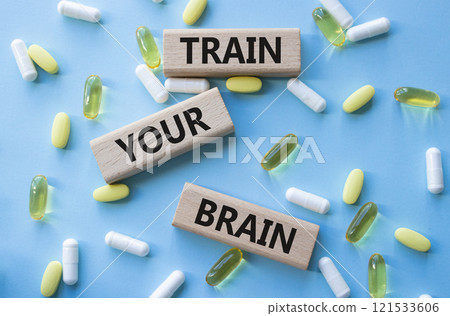 Train Your Brain symbol. Concept words Train Your Brain on wooden blocks. Beautiful blue background with pills. Healthcare and Train Your Brain concept. Copy space. Train Your Brain symbol. Concept words Train Your Brain on wooden blocks. Beautiful blue background with pills. Healthcare and Train Your Brain concept. Copy space. 121533606
