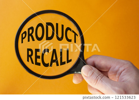 Product recall symbol. Concept words Product recall on magnifying glass. Beautiful orange background. Businessman hand. Business and Product recall concept. Copy space. 121533623