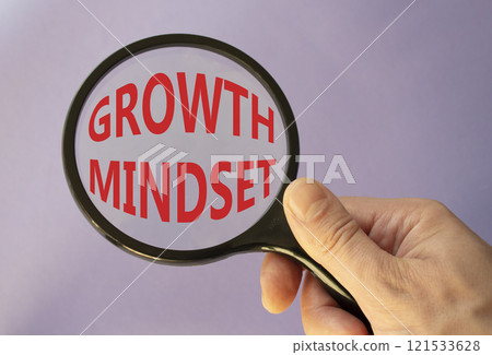 Growth Mindset symbol. Concept word Growth Mindset on magnifying glass. Beautiful purple background. Businessman hand. Business and Growth Mindset concept. Copy space 121533628
