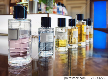 Collection of elegant perfume bottles arranged neatly on a wooden dresser in a bright retail shop Collection of elegant perfume bottles arranged neatly on a wooden dresser in a bright retail shop 121534272