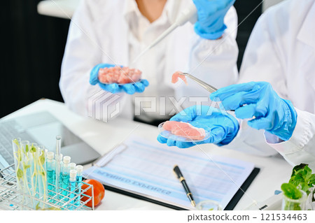 Food scientists in lab coats, testing samples, and analyzing food safety and quality 121534463