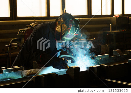 Skilled welder working diligently in a bright industrial workshop Skilled welder working diligently in a bright industrial workshop 121535635