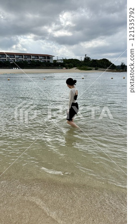 A woman playing with just her feet in the sea on Seragaki Island, Okinawa A woman playing with just her feet in the sea on Seragaki Island, Okinawa 121535792