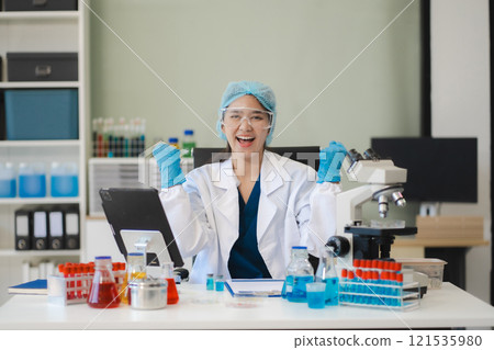 Successful young female Scientist giving victory thumbs up to show success and motivation. Successful young female Scientist giving victory thumbs up to show success and motivation. 121535980