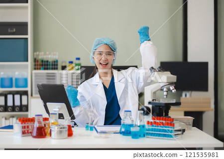 Successful young female Scientist giving victory thumbs up to show success and motivation. 121535981
