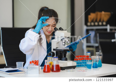 Chemist scientist holding test tube and tablet conducting experiment in laboratory with equipment, science concept. 121535997
