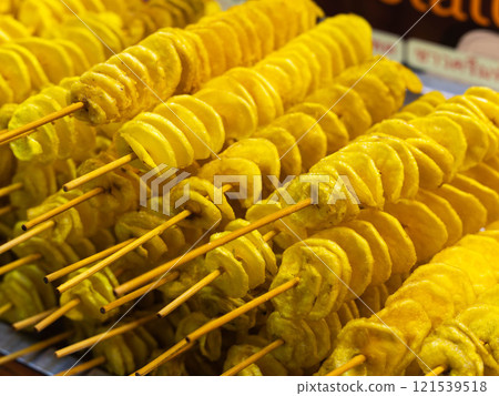 Spiral potatoes fried on a stick on a tray at a night market. Asian street food Thailand. 121539518