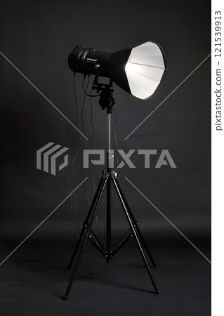 Studio spotlight: professional lighting equipment with fresnel lens on black background 121539913