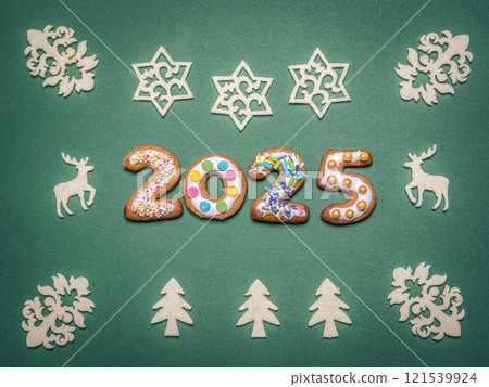 Festive 2025 Sign with Holiday Decor on a Green Background Festive 2025 Sign with Holiday Decor on a Green Background 121539924