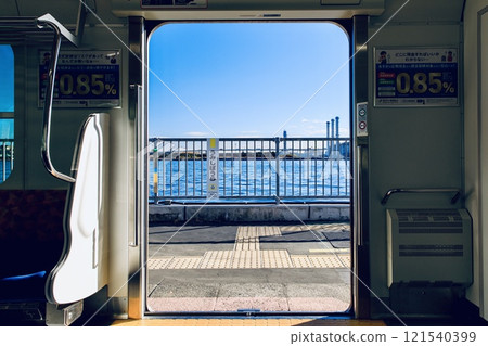 View of the platform at Umi-Shibaura Station and the Keihin Canal from inside a Tsurumi Line train 121540399