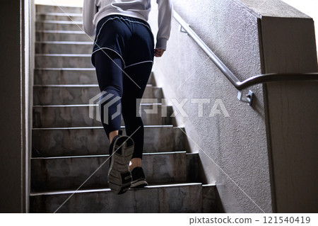 A woman who chooses to run up the stairs rather than the elevator Training Diet Exercise 121540419
