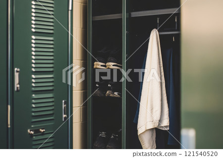 Open locker with towel and running shoes in gym changeroom 121540520