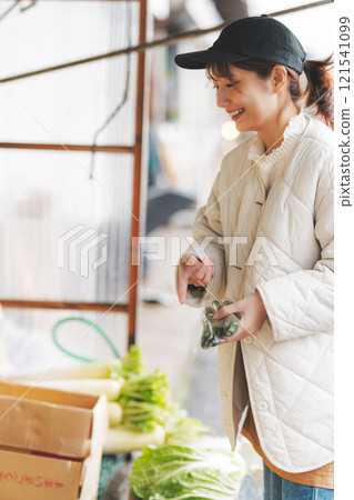 A young female sales clerk arranging products at a traditional fruit and vegetable store. (Photo courtesy of Nuttari Terrace Shopping Arcade) 121541099