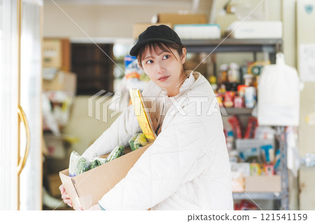 Portrait of a young female sales clerk working at a traditional fruit and vegetable store [Photo courtesy of Nuttari Terrace Shopping Arcade] 121541159