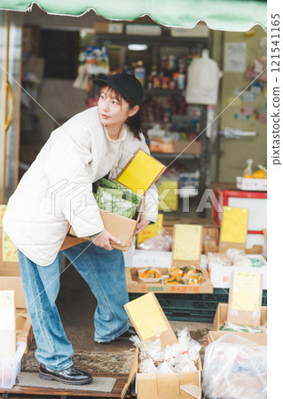 Portrait of a young female sales clerk working at a traditional fruit and vegetable store [Photo courtesy of Nuttari Terrace Shopping Arcade] 121541165