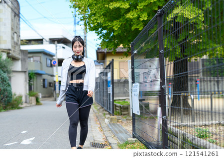 A cool woman walking outdoors along a park in a residential area Training Diet Exercise 121541261