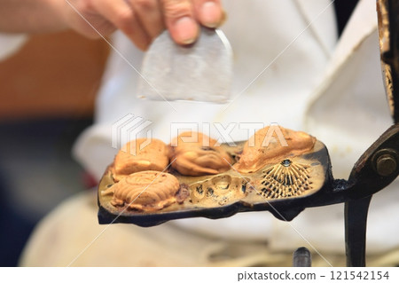 The hands of a craftsman making ningyo-yaki Handmade ningyo-yaki 121542154