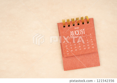 August 2025 red mini calendar on old brown paper. 121542356
