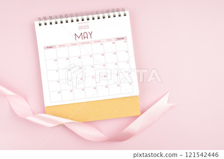May 2025 desk calendar with pink pastel ribbon. 121542446