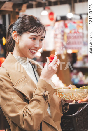 A young woman reminiscing about her past shopping at an old-fashioned candy store [Photo courtesy of Kagata Rice Store, rice and candy store] 121543708