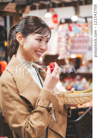 A young woman reminiscing about her past shopping at an old-fashioned candy store [Photo courtesy of Kagata Rice Store, rice and candy store] 121543709