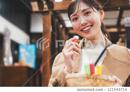 A young woman reminiscing about her past shopping at an old-fashioned candy store [Photo courtesy of Kagata Rice Store, rice and candy store] 121543714