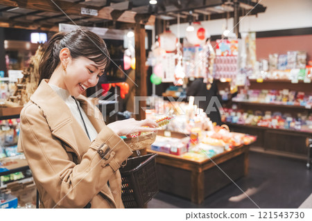 一位年輕女子懷舊地在老式糖果店購物[照片合作：大米/粗點心店加賀田Beikokuten] 121543730