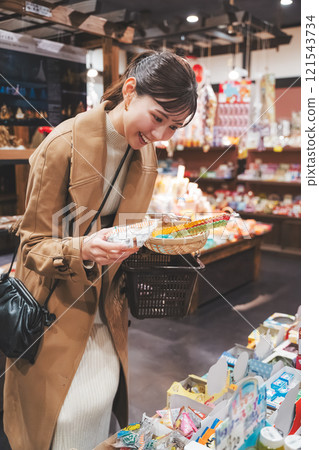 A young woman reminiscing about her past shopping at an old-fashioned candy store [Photo courtesy of Kagata Rice Store, rice and candy store] 121543734